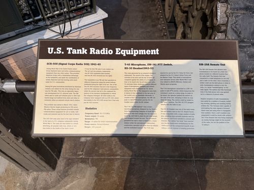 A clear, fully-legible placard titled 'U.S. Tank Radio Equipment' with four subsections: 'SCR-508 (Signal Corps Radio 508) 1942-45', 'T-45 Microphone, SW-141 PTT Switch, HS-30 Headset 1943-53', and 'RM-29A Remote Unit', plus a Statistics box. The actual radio set is visible above the sign.