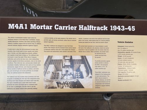 Placard titled 'M4A1 Mortar Carrier Halftrack 1943-45' with development text and a Vehicle Statistics box, photographed against the hull of the halftrack (vehicle number 7A75... visible above).