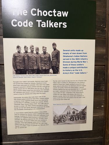 Tall story panel titled 'The Choctaw Code Talkers,' with a group photo of six Choctaw soldiers of the 36th Division (captioned with their names), a highlighted blue summary text block, several paragraphs of text, and a small photo of Native American recruits at Camp Bowie.