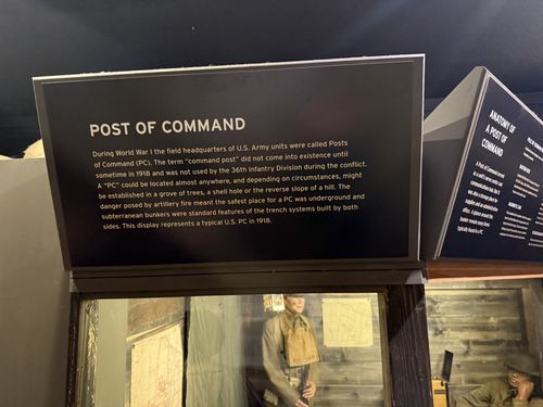 The 'POST OF COMMAND' title/intro panel above the diorama, a dark angled header with white text. To the right at an angle is the 'ANATOMY OF A POST OF COMMAND' panel (photographed in frame 72). Below, the doughboy mannequin and tacked-up situation maps are visible in the case.