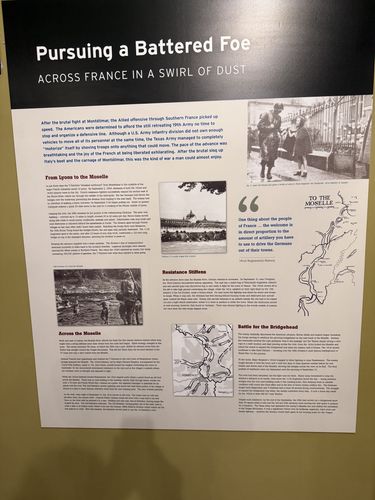 Wall panel titled 'Pursuing a Battered Foe' with a soldier portrait at top right, a vintage photo of the Moselle, a map directional inset reading 'TO THE MOSELLE,' and multiple text columns.
