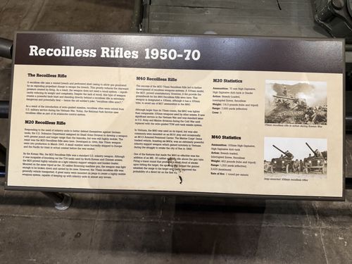 A long brown-and-tan museum placard titled 'Recoilless Rifles 1950-70', with sections on the recoilless rifle concept, the M20 and M40 recoilless rifles, statistics blocks, and photos of a 75mm recoilless rifle in the Korean War and jeep-mounted 106mm recoilless rifles.