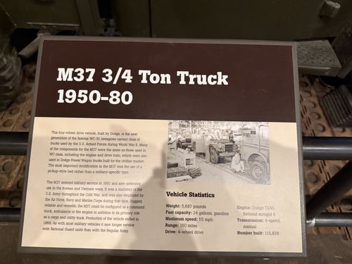 Close-up of the brown-and-tan placard titled 'M37 3/4 Ton Truck 1950-80', with descriptive text, a black-and-white photo of the truck, and a vehicle statistics block.
